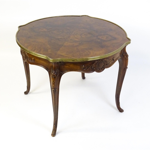 1623 - A Louis XV style centre table with a brass surround and a burr walnut veneered top above four carved... 