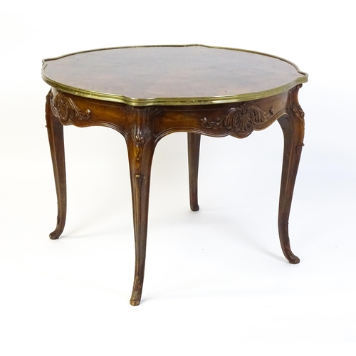 1623 - A Louis XV style centre table with a brass surround and a burr walnut veneered top above four carved... 