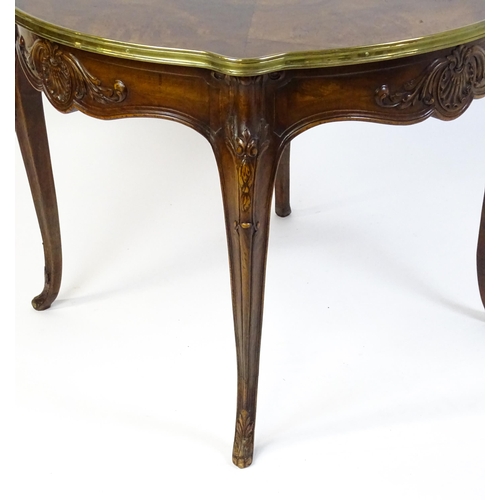 1623 - A Louis XV style centre table with a brass surround and a burr walnut veneered top above four carved... 