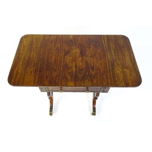 1626 - A 19thC rosewood work table / writing table with drop flaps to either side and two lyre shaped suppo... 