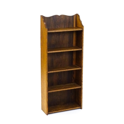 1630 - A small oak bookcase with a shaped upstand and five shelves, the backboard bearing a plaque 'Hollida... 