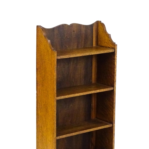 1630 - A small oak bookcase with a shaped upstand and five shelves, the backboard bearing a plaque 'Hollida... 