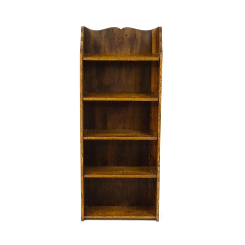 1630 - A small oak bookcase with a shaped upstand and five shelves, the backboard bearing a plaque 'Hollida... 