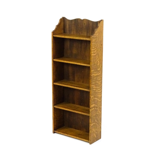 1630 - A small oak bookcase with a shaped upstand and five shelves, the backboard bearing a plaque 'Hollida... 