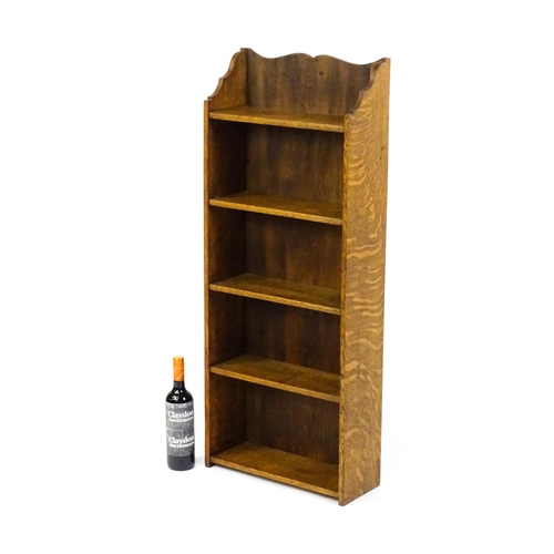 1630 - A small oak bookcase with a shaped upstand and five shelves, the backboard bearing a plaque 'Hollida... 