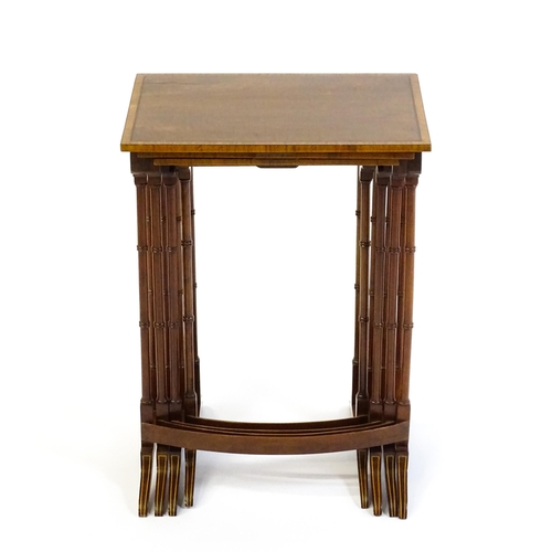 1634 - A nest of four early 20thC tables with crossbanded mahogany tops raised on turned tapering legs and ... 