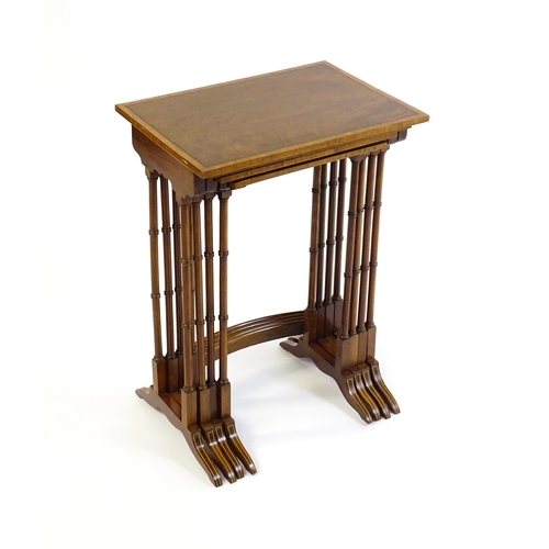 1634 - A nest of four early 20thC tables with crossbanded mahogany tops raised on turned tapering legs and ... 