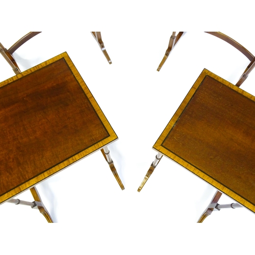 1634 - A nest of four early 20thC tables with crossbanded mahogany tops raised on turned tapering legs and ... 