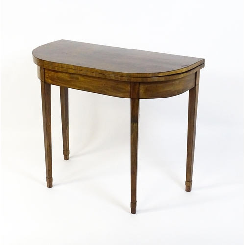 1640 - An early 19thC mahogany card table of demi lune form, the top opening to show a baize circular playi... 