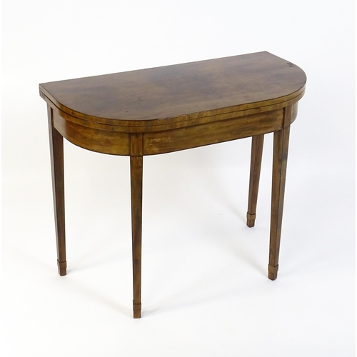 1640 - An early 19thC mahogany card table of demi lune form, the top opening to show a baize circular playi... 