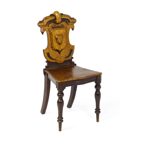 1641 - A Victorian oak shield back hall chair raised on baluster turned front legs and sabre back legs. 17