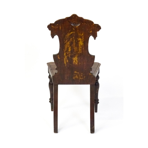 1641 - A Victorian oak shield back hall chair raised on baluster turned front legs and sabre back legs. 17