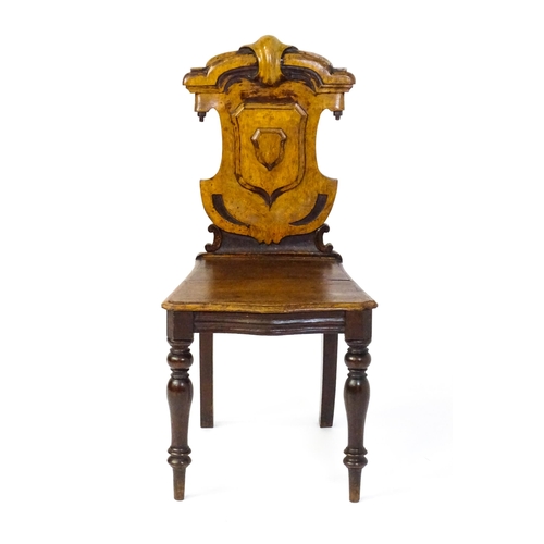 1641 - A Victorian oak shield back hall chair raised on baluster turned front legs and sabre back legs. 17