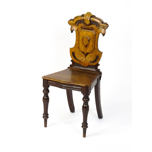 1641 - A Victorian oak shield back hall chair raised on baluster turned front legs and sabre back legs. 17