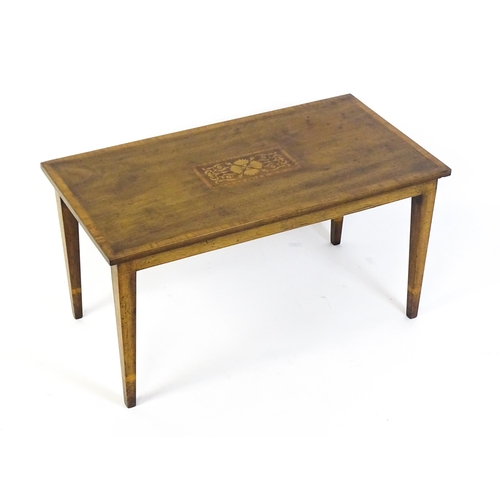 1643 - An early / mid 20thC mahogany coffee table with floral marquetry inlay and a crossbanded top raised ... 