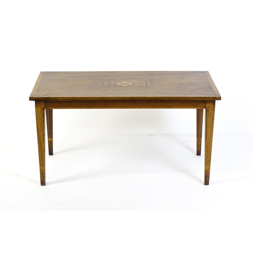 1643 - An early / mid 20thC mahogany coffee table with floral marquetry inlay and a crossbanded top raised ... 