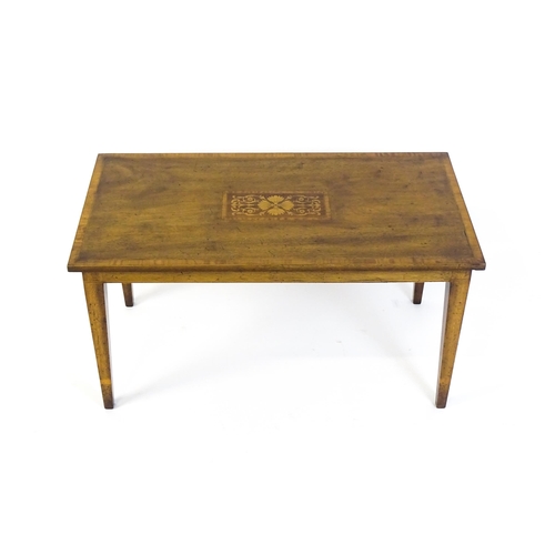 1643 - An early / mid 20thC mahogany coffee table with floral marquetry inlay and a crossbanded top raised ... 