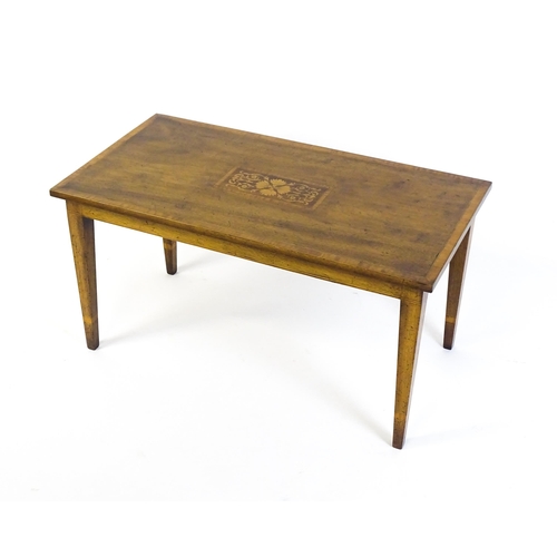 1643 - An early / mid 20thC mahogany coffee table with floral marquetry inlay and a crossbanded top raised ... 