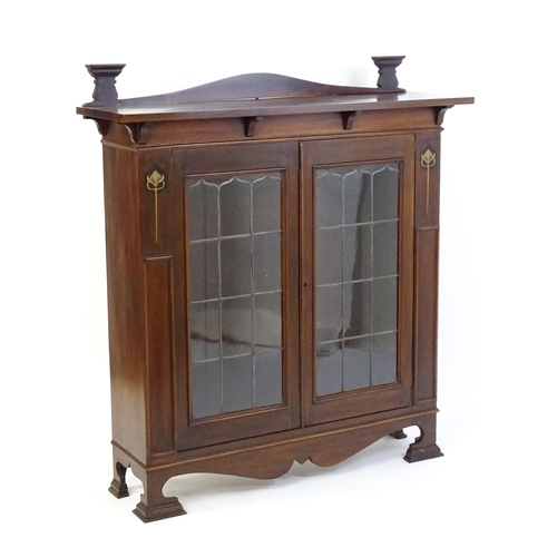 1647 - An Art Nouveau mahogany cabinet with a shaped upstand and two leaded glass doors with floral marquet... 