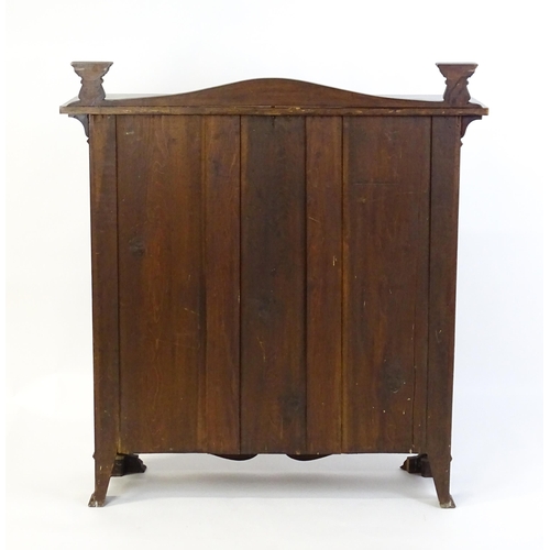 1647 - An Art Nouveau mahogany cabinet with a shaped upstand and two leaded glass doors with floral marquet... 