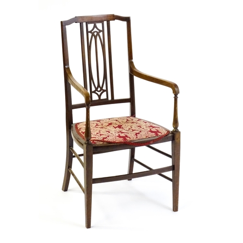 1652 - An Edwardian elbow chair with a burr walnut veneered top rail, a pierced back splat and swept arms o... 