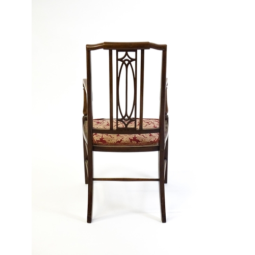 1652 - An Edwardian elbow chair with a burr walnut veneered top rail, a pierced back splat and swept arms o... 