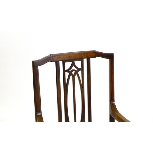 1652 - An Edwardian elbow chair with a burr walnut veneered top rail, a pierced back splat and swept arms o... 