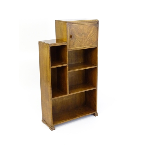 1667 - A mid 20thC walnut Art Deco bookcase / cabinet with open fronted shelves and raised on stepped feet.... 