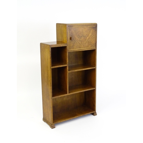 1667 - A mid 20thC walnut Art Deco bookcase / cabinet with open fronted shelves and raised on stepped feet.... 