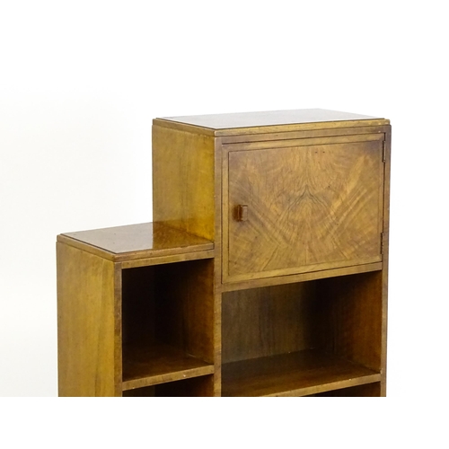 1667 - A mid 20thC walnut Art Deco bookcase / cabinet with open fronted shelves and raised on stepped feet.... 