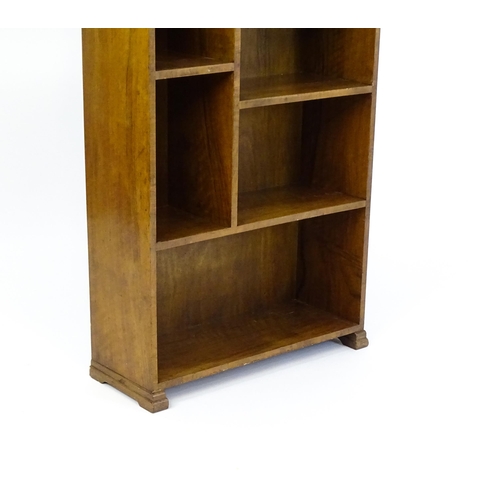 1667 - A mid 20thC walnut Art Deco bookcase / cabinet with open fronted shelves and raised on stepped feet.... 