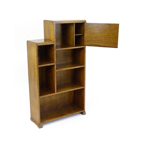 1667 - A mid 20thC walnut Art Deco bookcase / cabinet with open fronted shelves and raised on stepped feet.... 