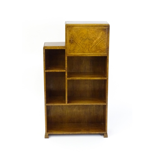 1667 - A mid 20thC walnut Art Deco bookcase / cabinet with open fronted shelves and raised on stepped feet.... 