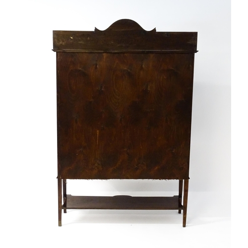 1670 - An Edwardian mahogany display cabinet with a shaped and moulded upstand, a satinwood inlaid frame wi... 