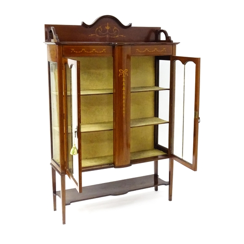 1670 - An Edwardian mahogany display cabinet with a shaped and moulded upstand, a satinwood inlaid frame wi... 