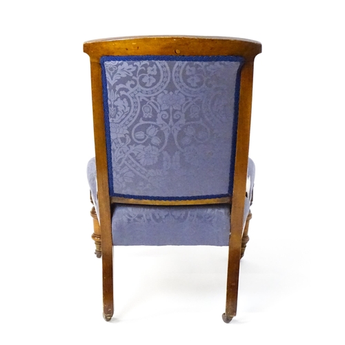 1680 - A late 19thC walnut nursing chair with a rosette carved top rail, and a sprung seat raised on turned... 