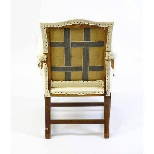 1681 - A Georgian library chair with unusual upholstered arms and raised on straight legs united by a H-str... 