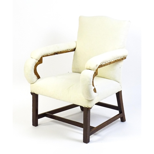 1681 - A Georgian library chair with unusual upholstered arms and raised on straight legs united by a H-str... 