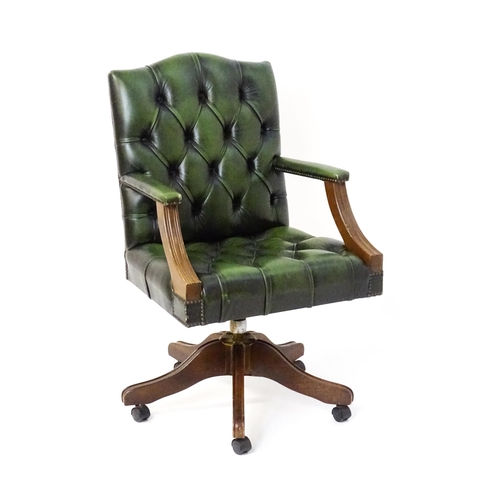 1684 - A late 20thC green leather captains chair with deep buttoned upholstery, reeded Gainsborough style a... 