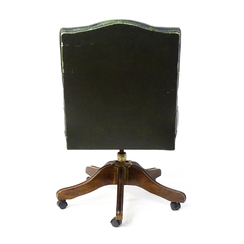 1684 - A late 20thC green leather captains chair with deep buttoned upholstery, reeded Gainsborough style a... 