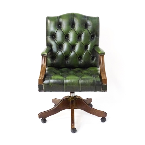 1684 - A late 20thC green leather captains chair with deep buttoned upholstery, reeded Gainsborough style a... 