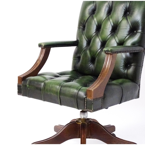 1684 - A late 20thC green leather captains chair with deep buttoned upholstery, reeded Gainsborough style a... 