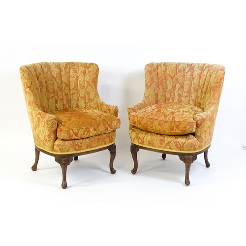 1685 - A pair of mid 20thC barrel back armchairs raised on acanthus carved cabriole legs terminating in car... 