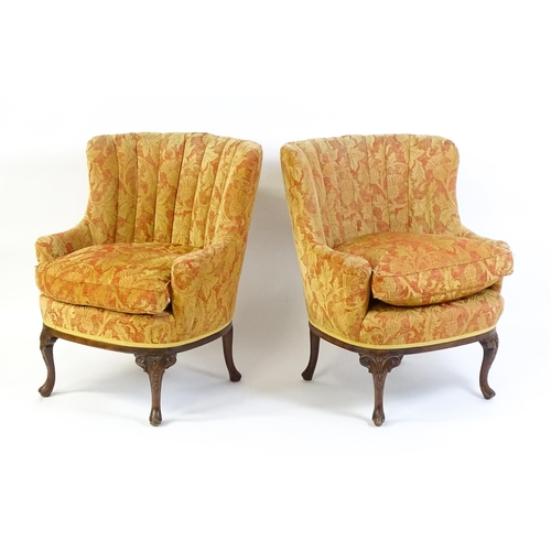 1685 - A pair of mid 20thC barrel back armchairs raised on acanthus carved cabriole legs terminating in car... 