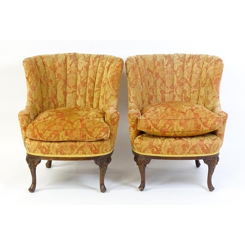 1685 - A pair of mid 20thC barrel back armchairs raised on acanthus carved cabriole legs terminating in car... 