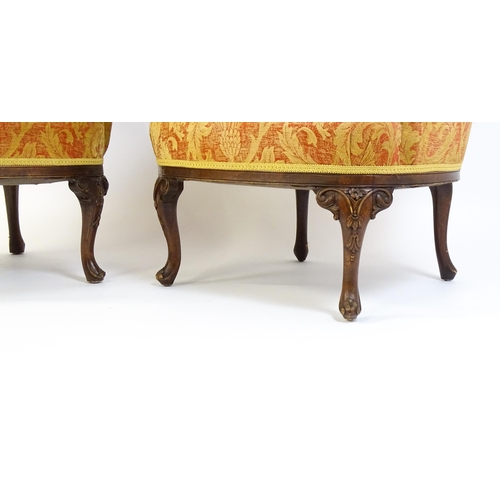 1685 - A pair of mid 20thC barrel back armchairs raised on acanthus carved cabriole legs terminating in car... 