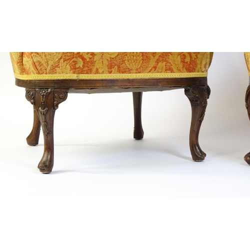 1685 - A pair of mid 20thC barrel back armchairs raised on acanthus carved cabriole legs terminating in car... 