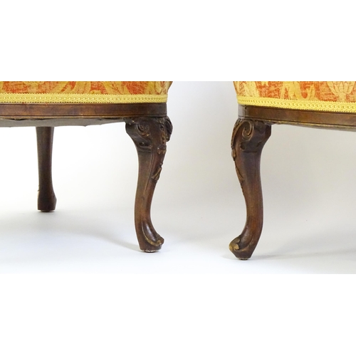 1685 - A pair of mid 20thC barrel back armchairs raised on acanthus carved cabriole legs terminating in car... 