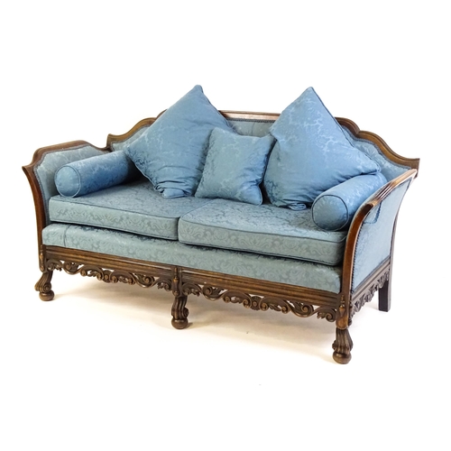 1687 - An early 20thC settee with a carved show wood frame and blue upholstery, the sofa having a carved an... 