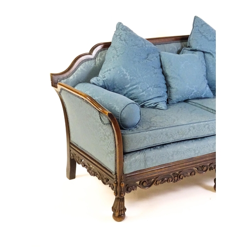 1687 - An early 20thC settee with a carved show wood frame and blue upholstery, the sofa having a carved an... 